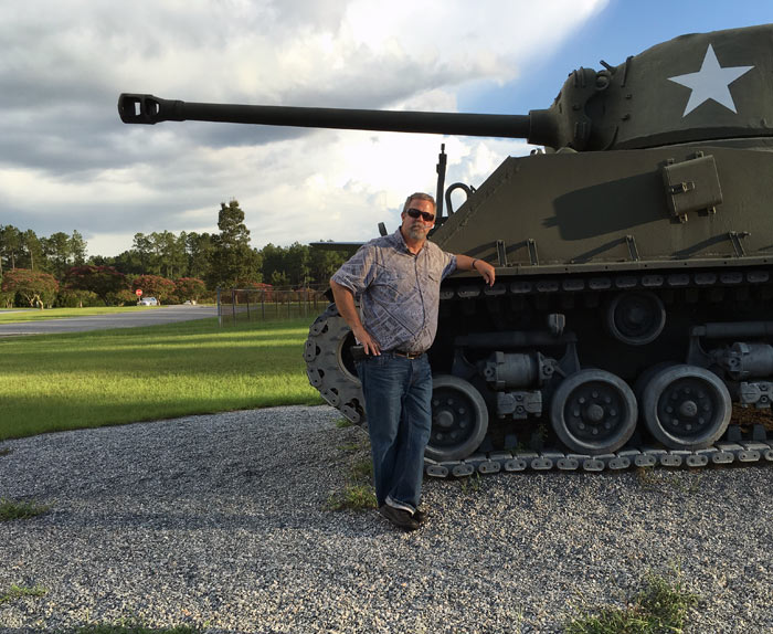 WildCow Logistics man, Charles standing next to Tank